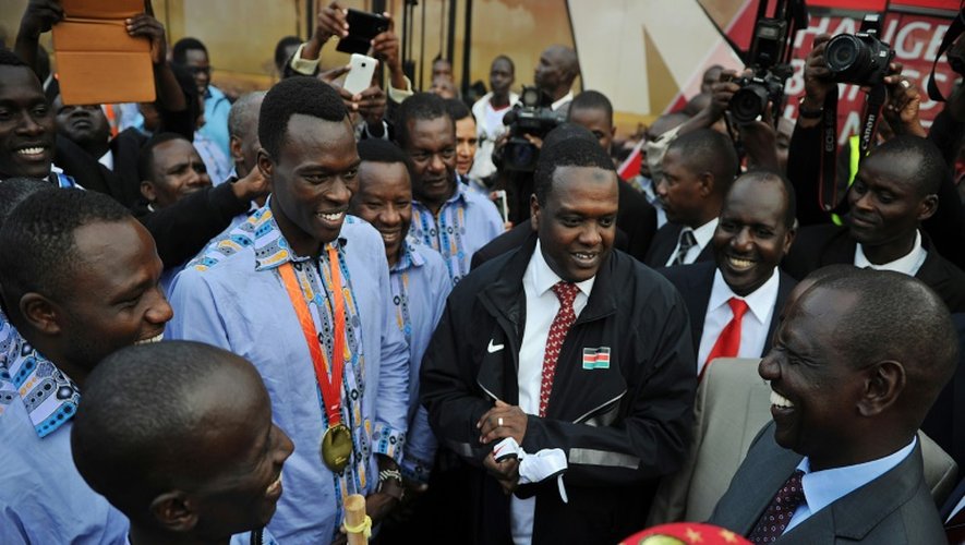 Le ministre des Sports kényan Hassan Wario (c) avec les médaillés des Mondiaux à leur retour à Nairobi, le 1er septembre 2015