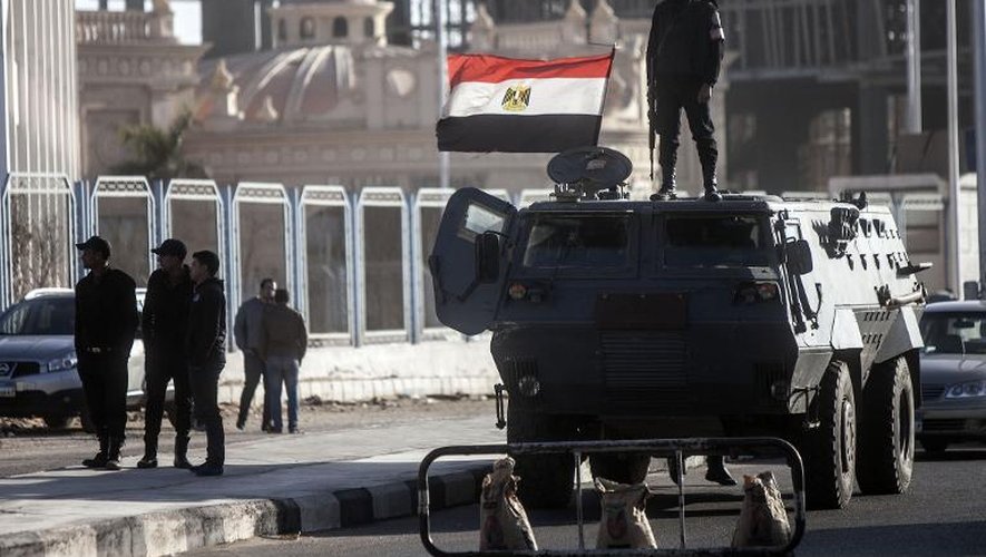 Des policiers anti-émeutes sont postés devant l'académie de police du Caire où l'audience de l'ancien président Mohamed Morsi a débuté le 28 janvier 2014