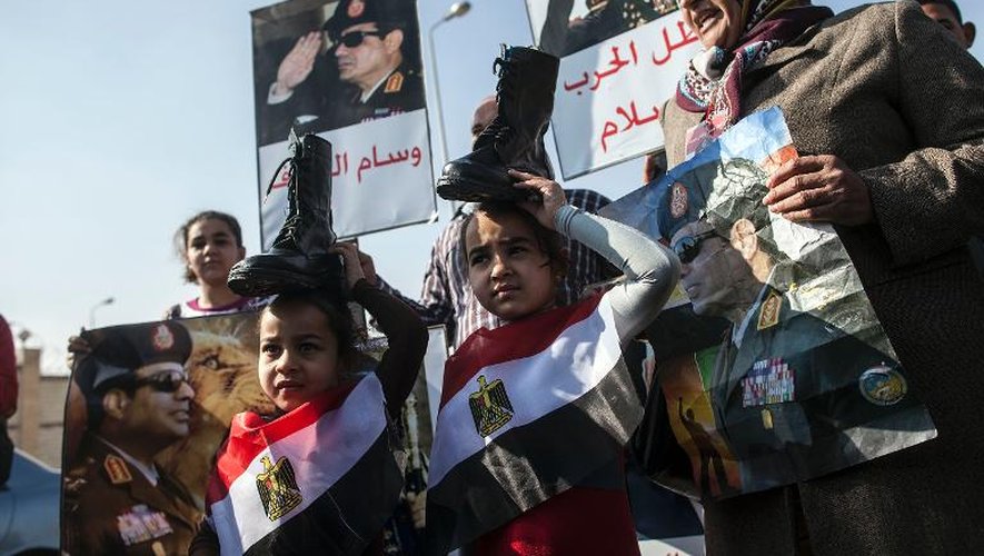 Des partisans du chef de l'armée égyptienne brandissent des bottes militaires sur leurs têtes comme signe d'allégence à l'armée, le 28 janvier 2014 au Caire