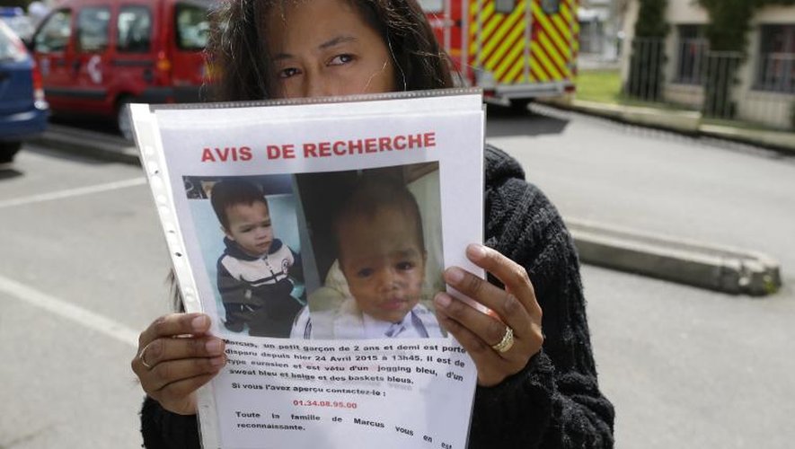 La mère du garçonnet disparu depuis vendredi dans la commune de Butry-sur-Oise (Val-d'Oise) tient un portrait de son enfant, le 25 avril 2015