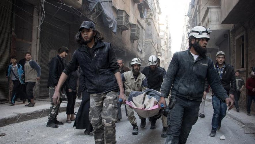 Des hommes portent le corps d'une femme sur un brancard, tuée lors d'une attaque des forces gouvernementales le 25 avril 2015 à Alep