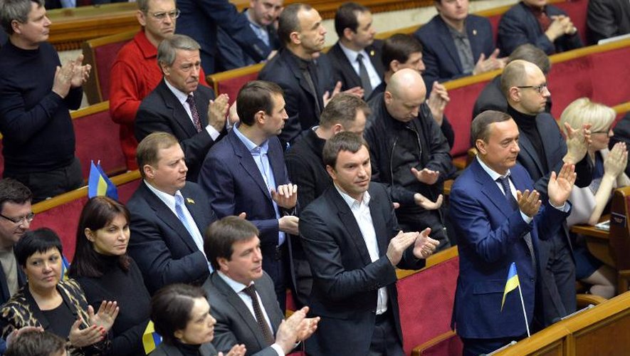 Des députés ukrainiens applaudissent après un vote du Parlement lors d'une session extraordinaire, le 28 janvier 2014 à Kiev