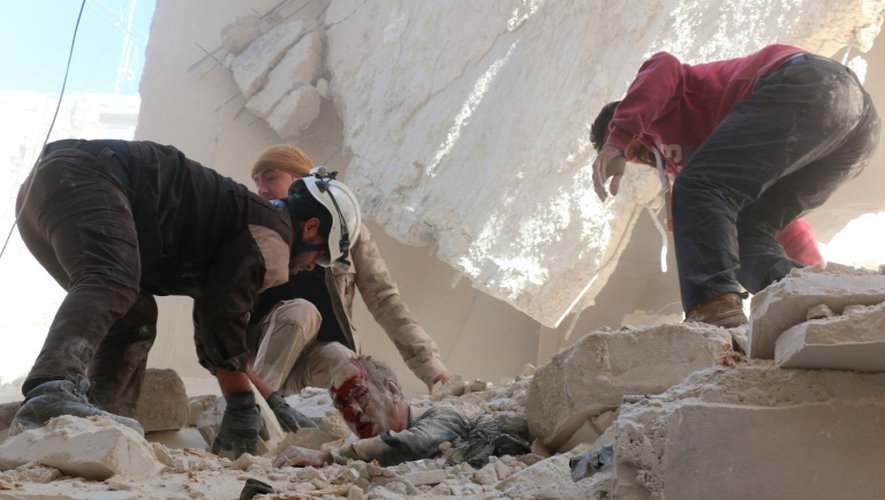 Un homme coincé dans les décombres d'un immeuble après un bombardement le 11 mars 2016 à Alep