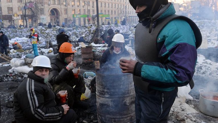 Des manifestants ukrainiens se réchauffent autour d'un feu près d'une barricade dans le centre de Kiev, le 30 janvier 2014