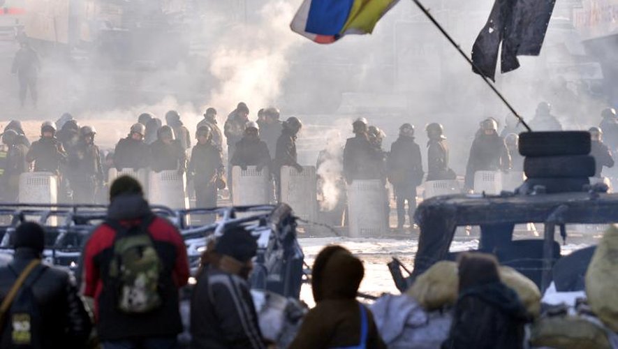 Des manifestants ukrainiens pro-européens derrière une barricade face aux policiers antiémeutes, le 30 janvier 2014 à Kiev
