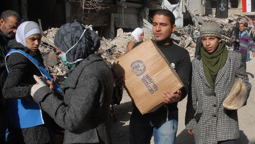 Des réfugiés palestiniens du camp de Yarmouk, au sud de Damas, reçoivent de l'aide alimentaire, le 30 janvier 2014