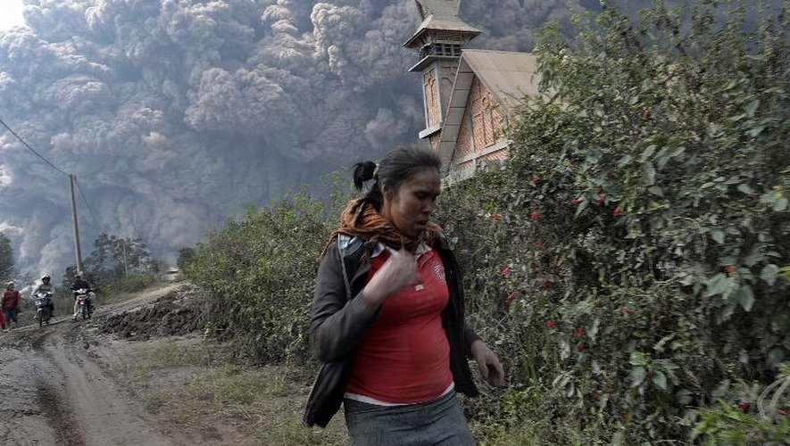 Une femme fuit l'éruption du volcan Sinabung (Sumatra Nord), le 1er février 2014