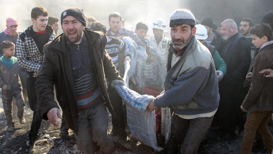 Des hommes transportent une victime, après un bombardement sur la ville d'Alep, le 1er février 2014