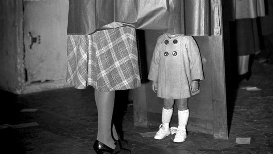 Une femme et sa petite fille dans l'isoloir dans un bureau de vote à Paris lors du référendum du 21 octobre 1945