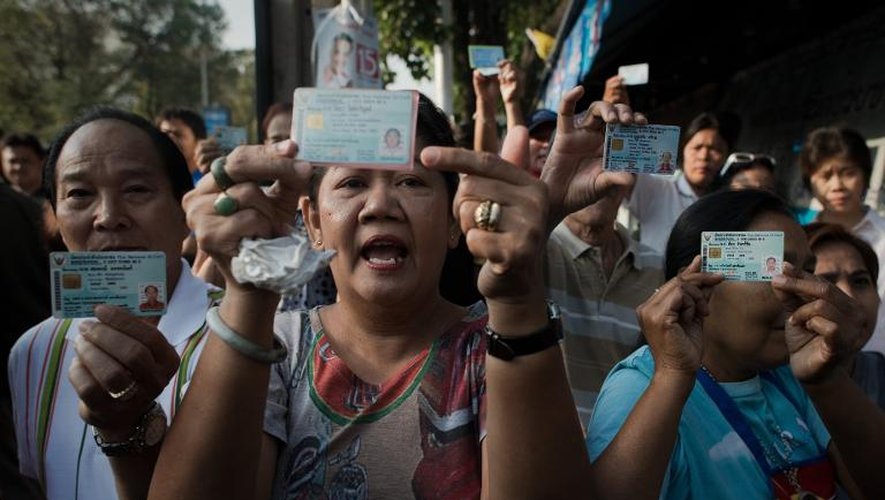 Des Thaïlandais qui n'ont pas pu voter dans leur quartier manifestent en montrant leurs cartes d'identité, le 2 février 2014 à Bangkok