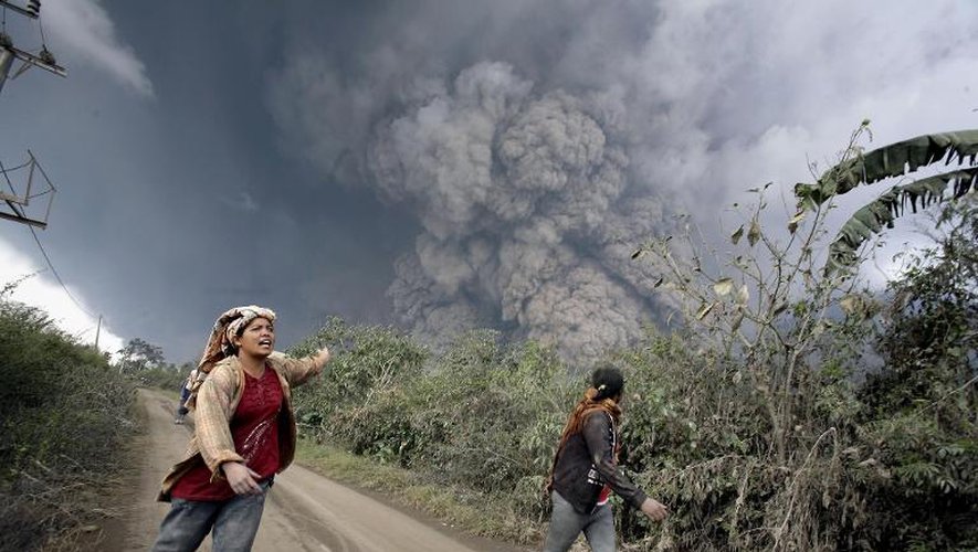 Des habitants courent pour échapper à une nuée ardente, lors d'une éruption volcanique, le 1er février 2014 à Karo, en Indonésie