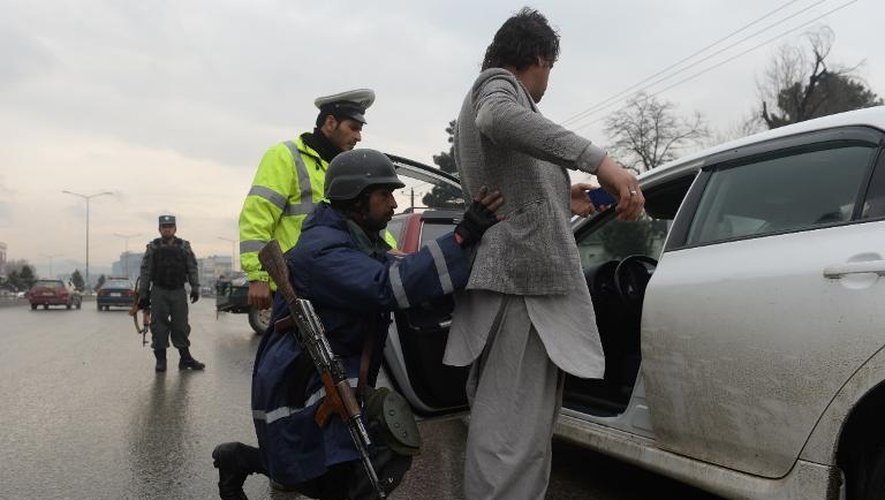 Des policiers contrôlent un automobiliste à un checkpoint à Kaboul au premier jour de la campagne présidentielle afghane, le 2 février 2014