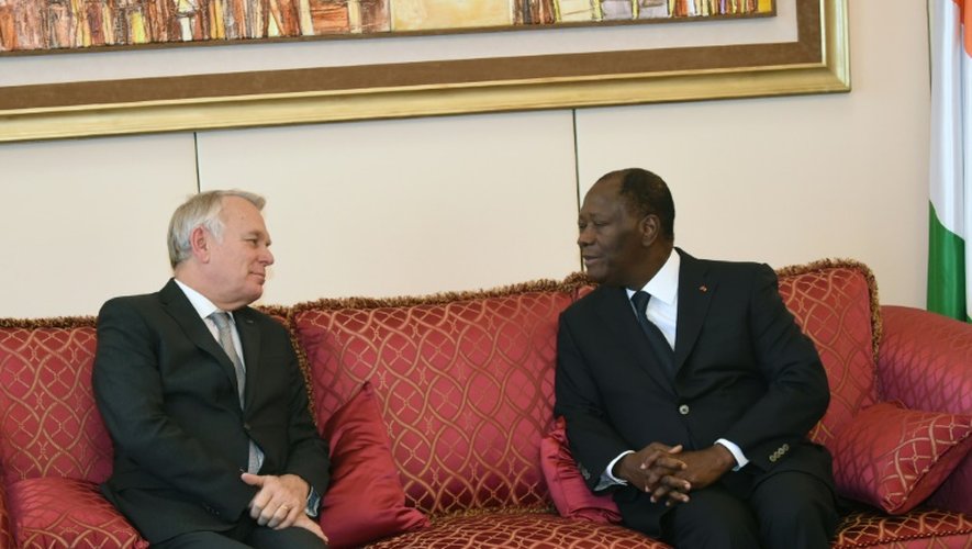 Le président ivoirien Alassane Ouattara(d) parle avec le ministre français des Affaires étrangères Jean-Marc Ayrault à Abidjan le 15 mars 2016