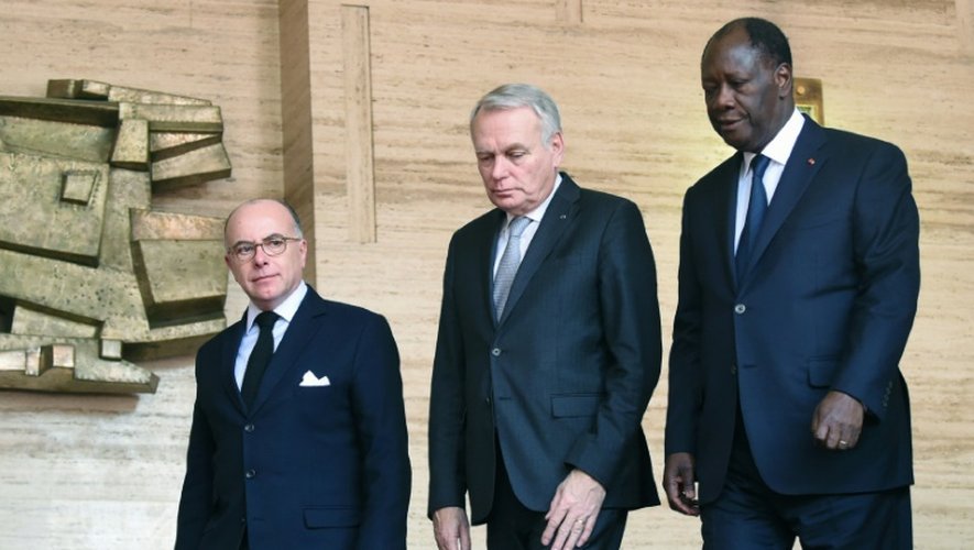 Le président ivoirien Alassane Ouattara (d) avec les ministres français des Affaires étrangères Jean-Marc Ayrault (c) et de l'Intérieur Bernard Cazeneuve (g) à Abidjan le 15 mars 2016