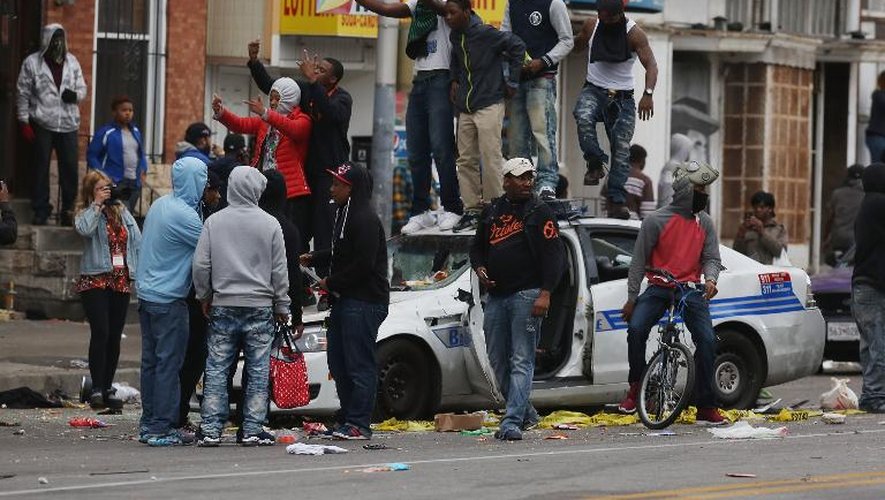 Des manifestants grimpent sur une voiture de police le 27 avril 2015, dans les rues de Baltimore en proie à des émeutes depuis quelques jours