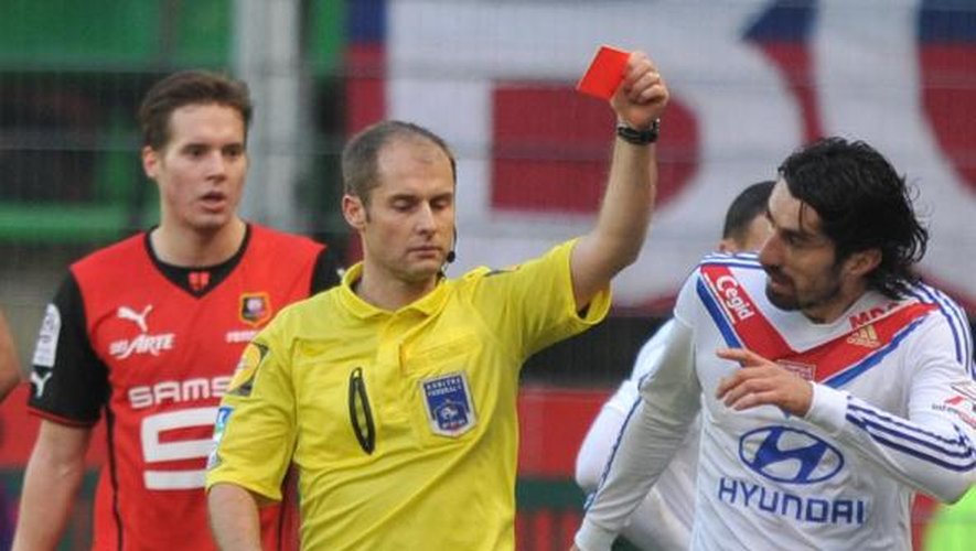 L'arbitre Philippe Kalt donne un carton rouge au défenseur de Lyon Samuel Umtiti lors du match contre Rennes le 2 février 2014 à Rennes