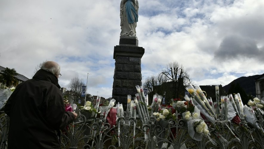 Un fidèle devant une statue de la Vierge Marie à Lourdes le 11 février 2016