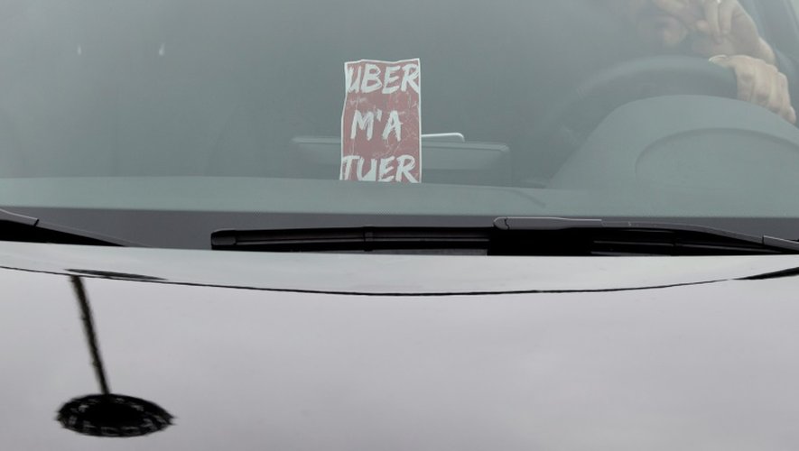 Des chauffeurs travaillant pour Uber manifestent contre les baisses de prix imposées par la plate-forme de réservation place de la Porte Maillot à Paris le 18 décembre 2015