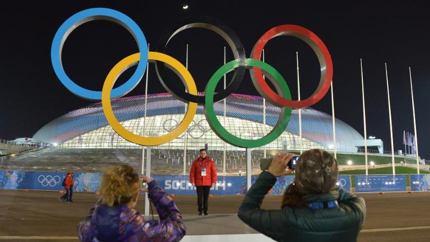 Des touristes se prennent en photo devant les anneaux olympiques à Sotchi, le 3 février 2014