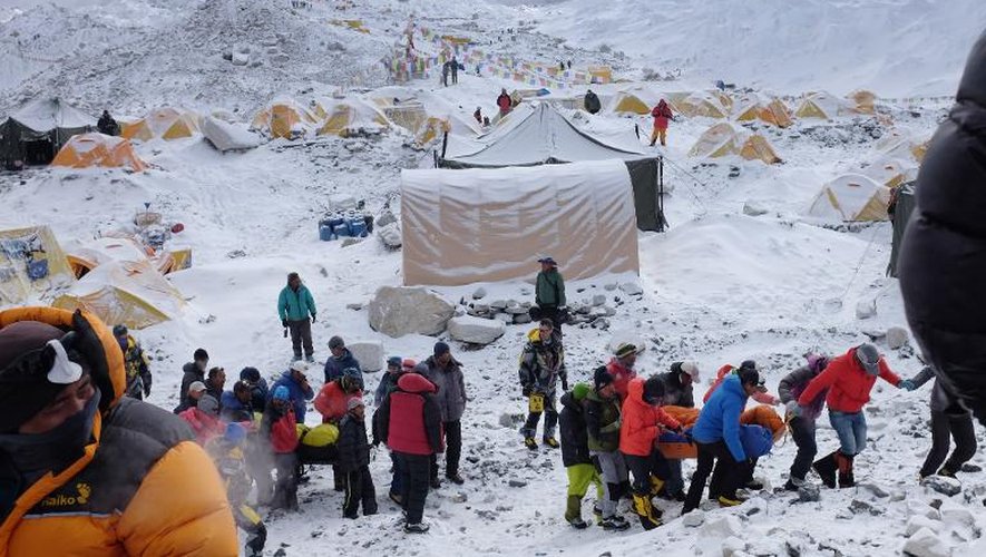 Des secouristes transportent des blessés sur le camp de base de l'Everest après l'avalanche provoquée par le tremblement de terre le 26 avril 2015