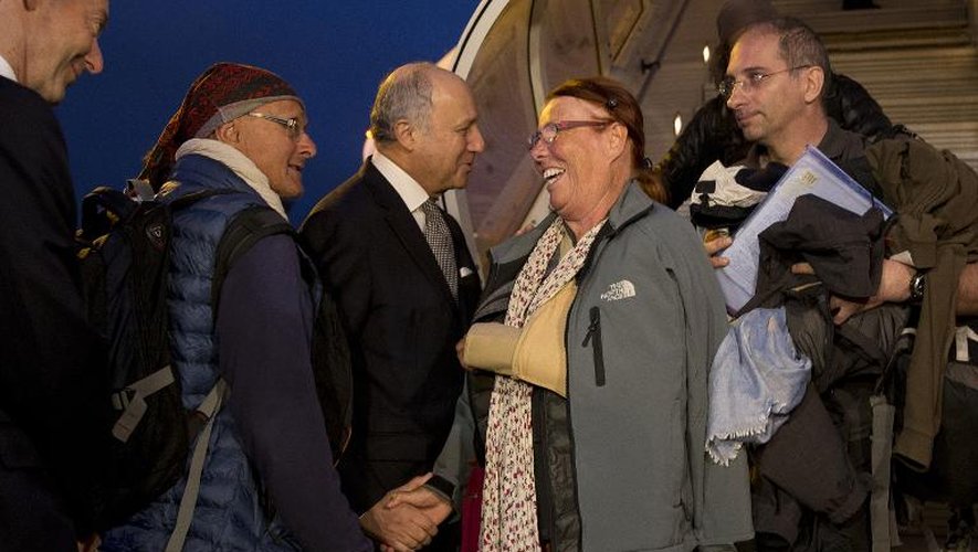 Le ministre des Affaires étrangères Laurent Fabius accueille à Roissy le 30 avril 2015 des réscapés du séisme au Népal