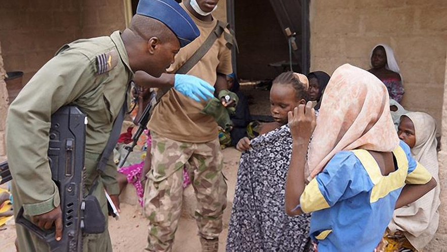 Photo fournie par l'armée nigériane le 30 avril 2015 prise dans un lieu non divulgué de l'Etat de Borno montrant un militaire discutant avec des jeunes filles libérées lors d'une opération contre le groupe islamiste Boko Haram