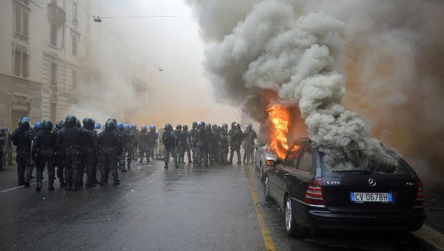 La police italienne charge le 1er mai 2015 contre des manifestantes anti-Expo dans une rue de Milan où une voiture a été brûlée