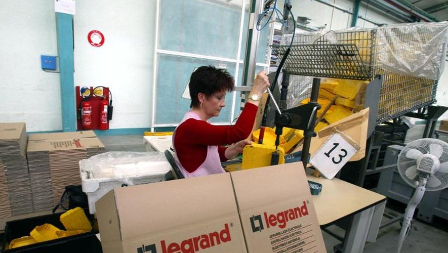 Dans l'usine Legrand à Limoges, une ouvrière emballe du matériel électrique, le 18 février 2002