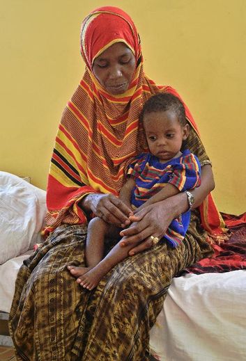 Mariam Mohamed Musa tient dans ses bras son fils Sabir Adan de 15 mois souffrant de problèmes respiratoires dans un centre de soins à Mogadiscio, le 25 mars 2015