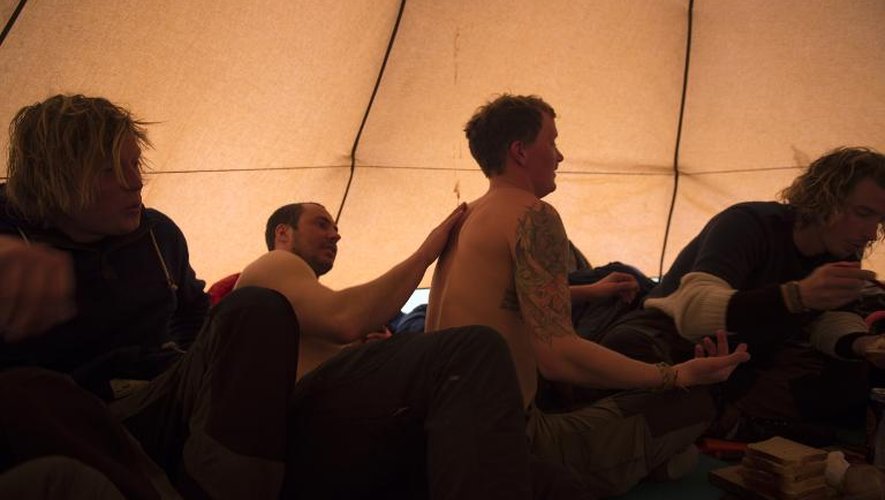 Des touristes suédois tentent de se   réchauffer dans leur tente après avoir surfé à Unstad Beach dans l'archipel norvégien des Lofoten, le 17 avril 2015