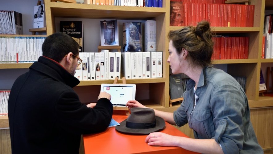 Des clients de la nouvelle librairie des Presses universitaires de France choisissent sur une tablette les livres qu'ils veulent imprimer, à Paris, le 16 mars 2016