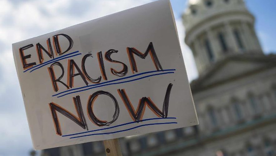 Une pancarte appellant à mettre fin au racisme est brandi devant la mairie de Baltimore dans le cadre de la manifestation pour dénoncer les brutalités policières, le 2 mai 2015