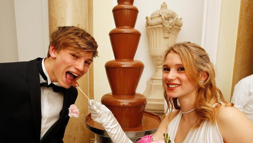 Un jeune couple s'amuse d'une fontaine de chocolat à l'ouverture du Bal des confiseurs au palais Hofburgh de Vienne le 16 janvier 2014
