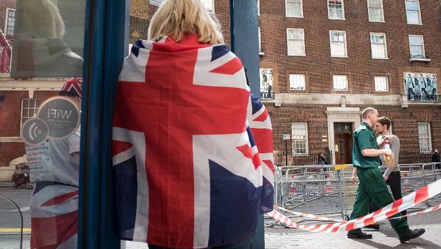 Une femme enroulée dans le drapeau britannique devant l'hôpital Saint Mary le 16 avril 2015 à Londres