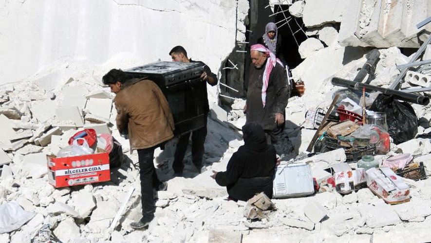 Des habitants d'Alep récupèrent, le 6 février 2014, des affaires dans un immeuble détruit par des bombardements aériens