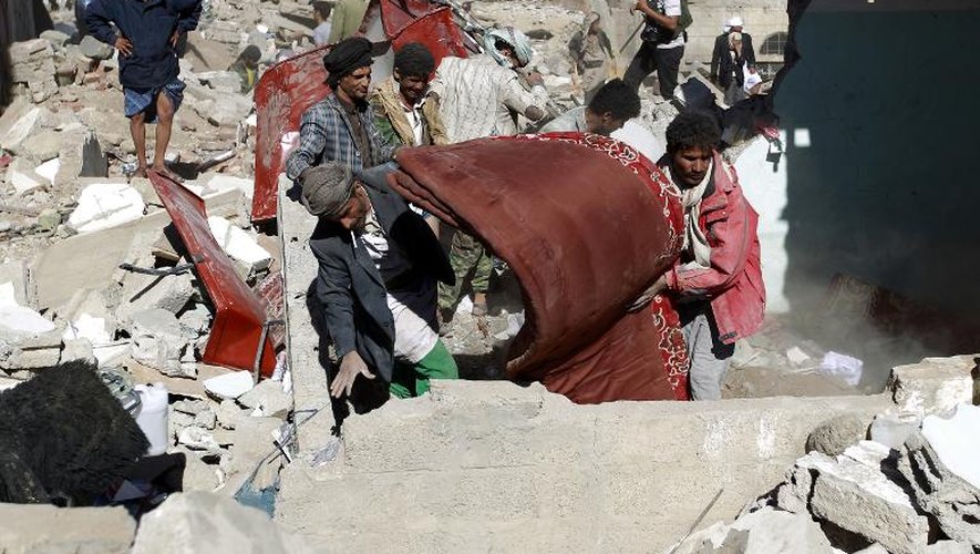Des Yéménites récupèrent des biens des débris des maisons détruites par les raids aériens conduits par l'Arabie saoudite, le 1er mai 2015 à Sanaa, la capitale du pays