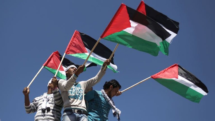 Des hommes portent le drapeau palestinient à Gaza, le 15 mai 2013