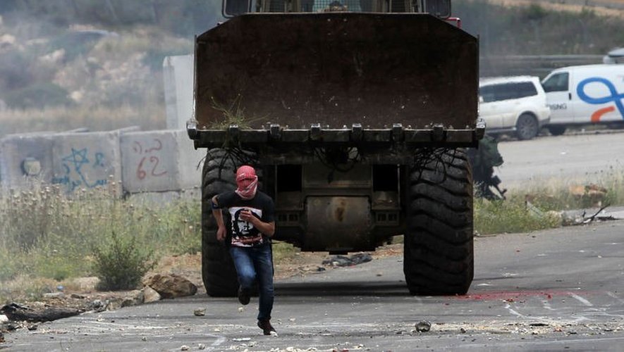 Un Palestinien fuit un char israélien, à Gaza, le 15 mai 2013
