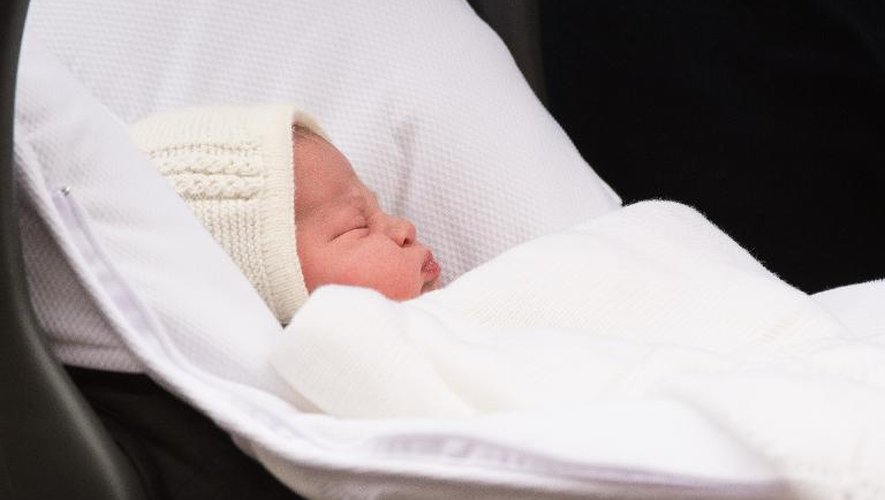 La petite princesse est installée dans un cosy et sort de la maternité portée par son pape le Prince William, le 2 mai 2015