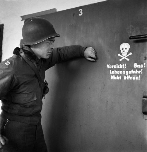 Un soldat américain devant une chambre à gaz en avril 1945 à Dachau