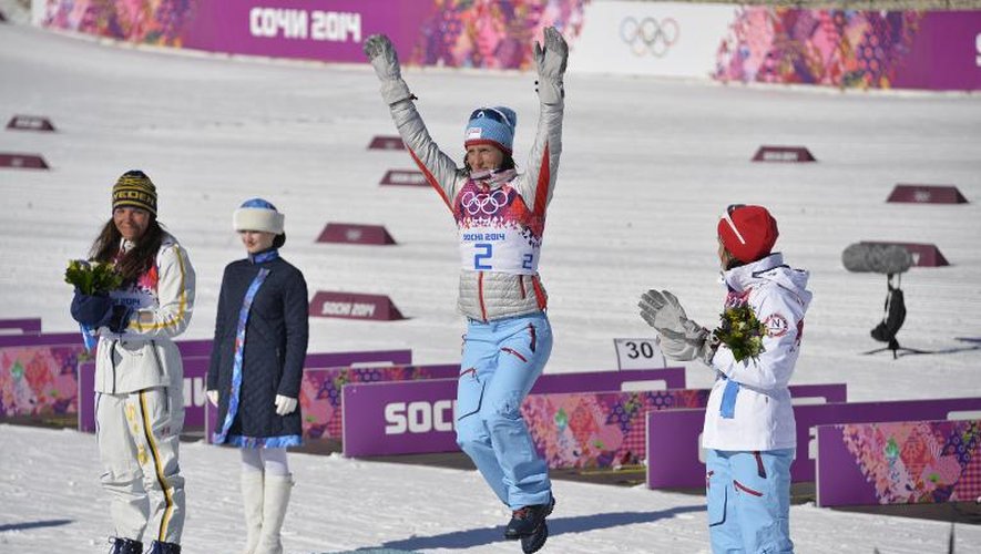 La Norvégienne Marit Bjoergen (C) sur la plus haute marche du podium du skiathlon célèbre sa victoire devant la Suédoise Charlotte Kalla (G) et sa compatriote Heidi Weng (D) à Sotchi, le 8 février 2014