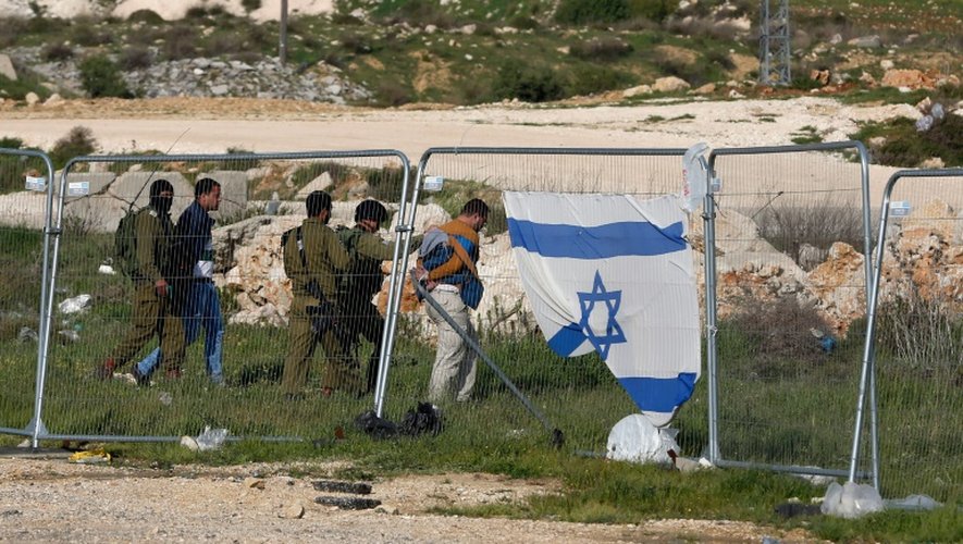 Les forces de sécurité israéliennes détiennent des Palestiniens après une attaque au couteau à Goush Etzion, sur le grand axe qui traverse la Cisjordanie du nord au sud et relie Jérusalem à Hébron, le 18 mars 2016