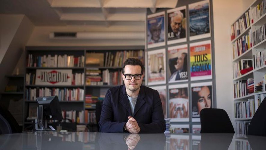 Nicolas Demorand le 17 juin 2013 dans son bureau de Libération, devant des "unes "historiques du quotidien que la direction veut transformer en réseau social et espace culturel