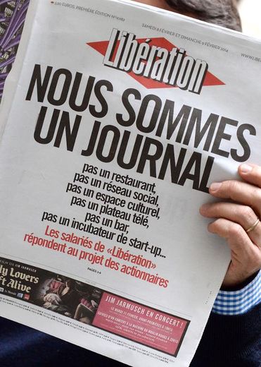 Un homme lit le journal Libération samedi 8 février 2014, dont la Une est titrée "Nous sommes un journal", réponse de la rédaction aux propositions des actionnaires qui souhaitent transformer le quotidien en réseau social et espace cultu