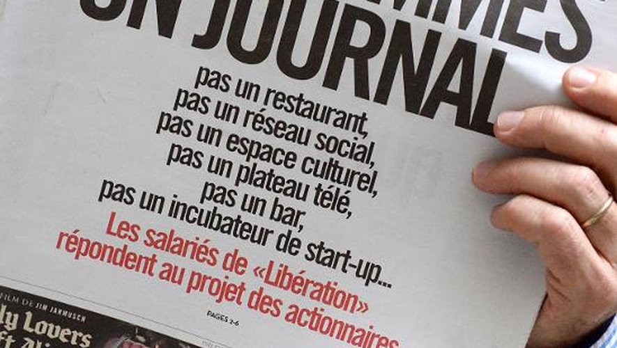 Un homme lit le journal Libération samedi 8 février 2014, dont la Une est titrée "Nous sommes un journal", réponse de la rédaction aux propositions des actionnaires qui souhaitent transformer le quotidien en réseau social et espace cultu