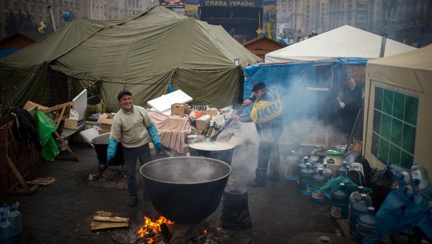 Deux hommes cuisinent sur la place de l'Indépendance Euromaidan à Kiev pour nourrir les manifestants anti-gouvernementaux, le samedi 8 décembre 2014