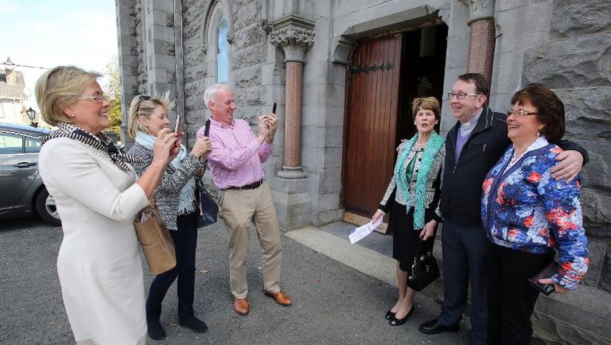 Le père irlandais Ray Kelly pose le 19 avril 2015 avec des admiratrices devant la chapelle de Oldcastle, à une centaine de kilomètres de Dublin