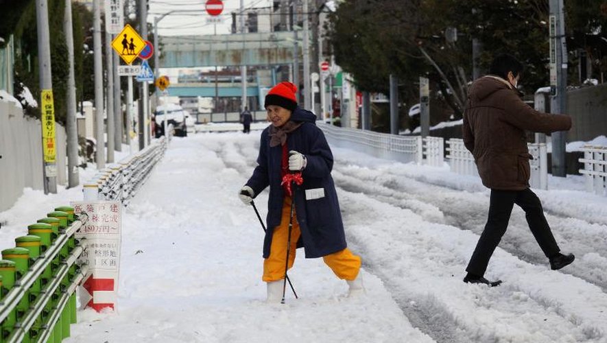 Une femme traverse une route recouverte de neige à Tokyo, le 9 février 2014