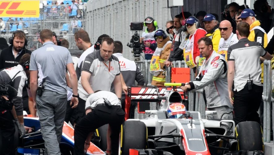 Des mécaniciens s'activent autour de la Manor de Romain Grosjean lors des qualifications pour le GP d'Australie, le 19 mars à Melbourne