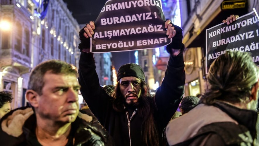 Des personnes brandissent des pancartes indiquant "nous n'avons pas peur, nous sommes ici, nous n'allons pas nous laisser faire", le 20 mars 2016 dans le centre d'Istanbul au lendemain de l'attentat qui a fait 4 morts